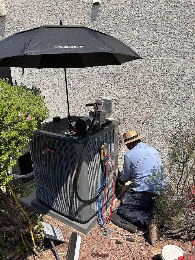 HVAC technician performing outdoor AC maintenance in Lander