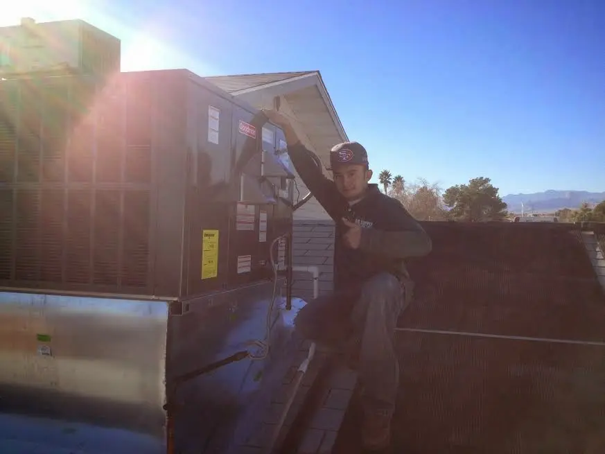 HVAC technician performing AC Tune-Up on a rooftop unit in Lander